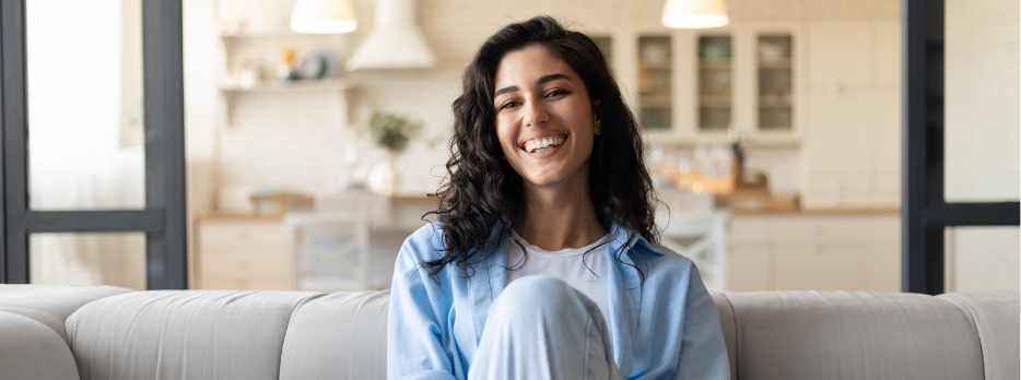 Female patient sitting in dental chair and smiling at dentist in Rogers